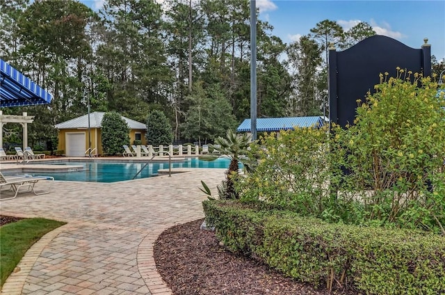 view of pool featuring an outbuilding and a patio area