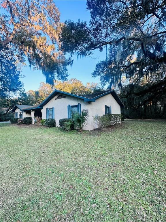 view of property exterior featuring a lawn and stucco siding