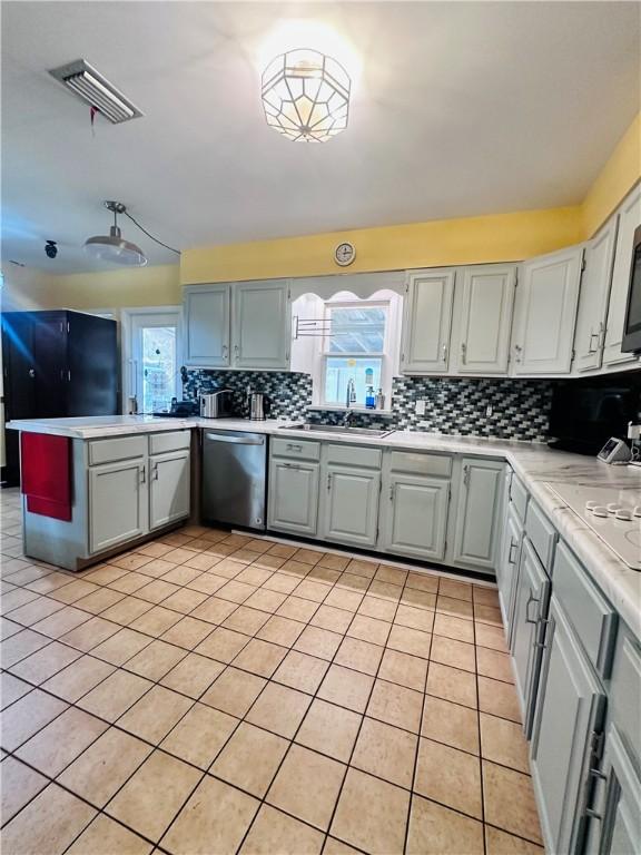 kitchen featuring dishwasher, a healthy amount of sunlight, visible vents, and backsplash