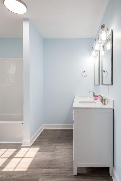 3 Dixon Ln, Blackshear, GA 31516 - full bath with double vanity, wood finished floors, baseboards, and bathing tub / shower combination