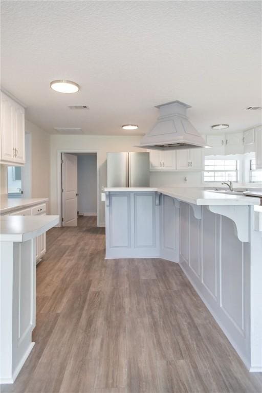 3 Dixon Ln, Blackshear, GA 31516 - kitchen with freestanding refrigerator, custom exhaust hood, light countertops, and a kitchen breakfast bar