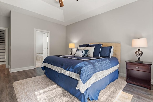 bedroom featuring wood finished floors, baseboards, and ensuite bathroom