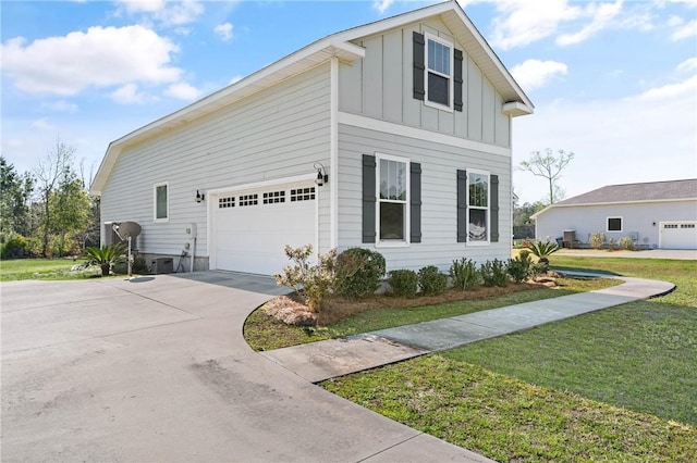 view of side of property featuring a garage, board and batten siding, driveway, and a yard