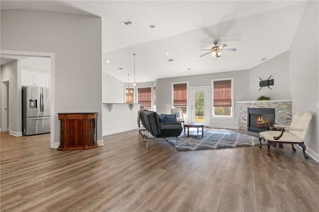 living room featuring vaulted ceiling, wood finished floors, and a fireplace