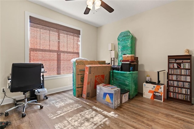 office space featuring baseboards, wood finished floors, and a ceiling fan