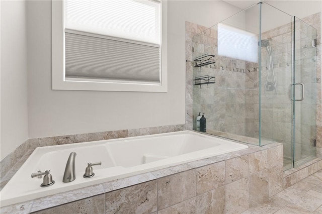 full bathroom featuring a bath and a stall shower