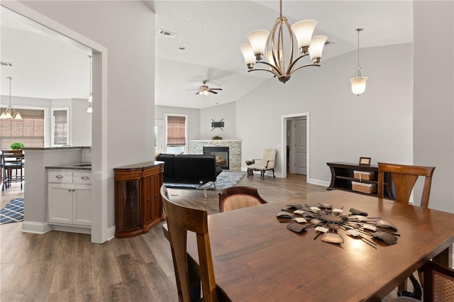 dining space featuring a glass covered fireplace, wood finished floors, and a wealth of natural light