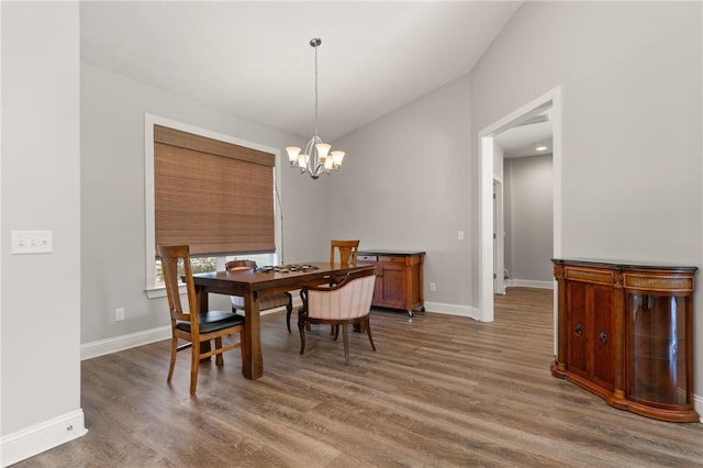 dining room featuring baseboards, a notable chandelier, and wood finished floors