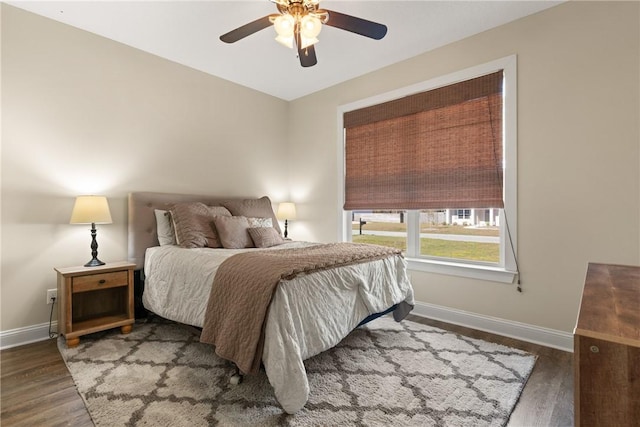 bedroom with ceiling fan, baseboards, and wood finished floors