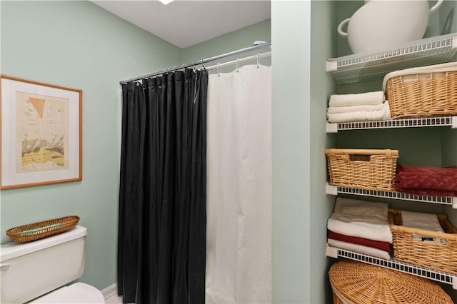 bathroom with curtained shower and toilet