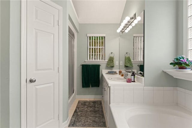 bathroom featuring a bathing tub, vanity, and tile patterned flooring