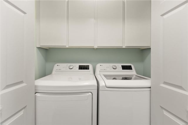 washroom featuring cabinets and separate washer and dryer