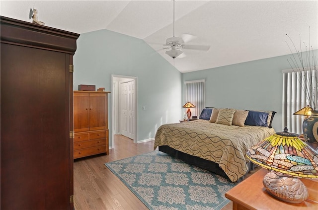 bedroom with hardwood / wood-style flooring, ceiling fan, and lofted ceiling