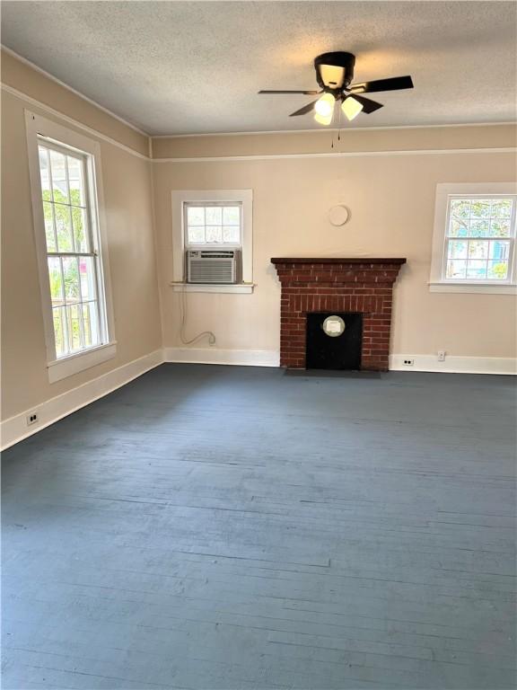 1108 George St, Brunswick, GA 31520 - unfurnished living room featuring healthy amount of natural light, a textured ceiling, cooling unit, a fireplace, and a ceiling fan