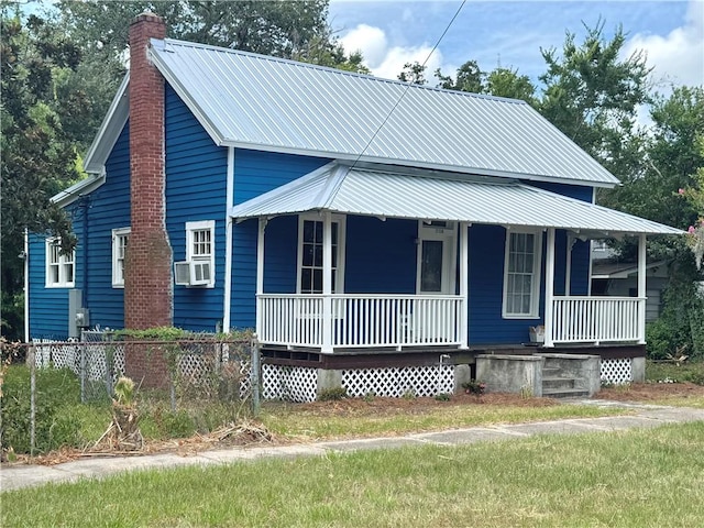 1108 George St, Brunswick, GA 31520 - view of front facade featuring a porch, a chimney, a metal roof, and cooling unit