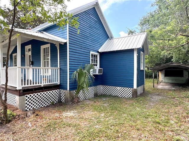 1108 George St, Brunswick, GA 31520 - view of side of property featuring covered porch, a carport, a metal roof, a lawn, and cooling unit