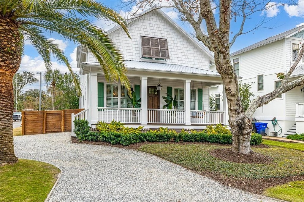421 Union St, Saint Simons Island, GA 31522 - view of front facade with gravel driveway, a porch, fence, and metal roof