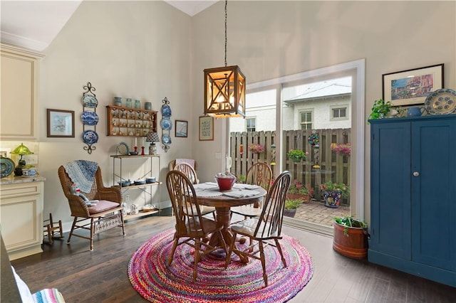 dining space with dark hardwood / wood-style flooring, a chandelier, and vaulted ceiling