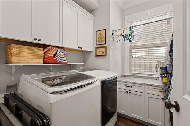 clothes washing area featuring washing machine and dryer and cabinets