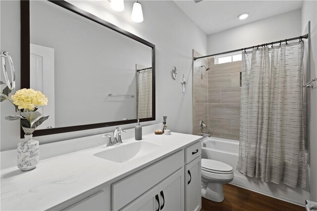 138 Clearwater Dr, Brunswick, GA 31523 - bathroom with vanity, shower / bathtub combination with curtain, toilet, and wood finished floors