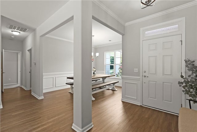 138 Clearwater Dr, Brunswick, GA 31523 - foyer with dark wood finished floors, ornamental molding, a chandelier, a wainscoted wall, and a decorative wall