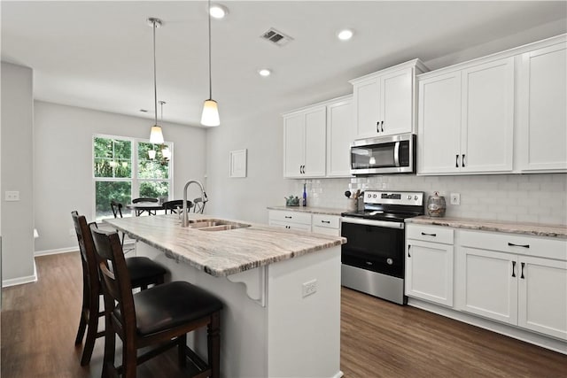 138 Clearwater Dr, Brunswick, GA 31523 - kitchen with stainless steel appliances, a sink, decorative backsplash, a center island with sink, and recessed lighting