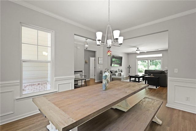 138 Clearwater Dr, Brunswick, GA 31523 - dining area featuring a chandelier, crown molding, dark wood-type flooring, a wainscoted wall, and ceiling fan