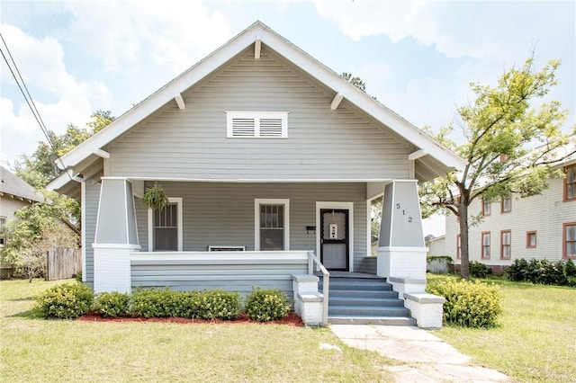 bungalow-style home featuring a front yard and covered porch