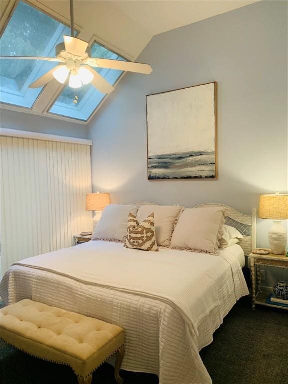 bedroom featuring lofted ceiling with skylight, carpet, and ceiling fan