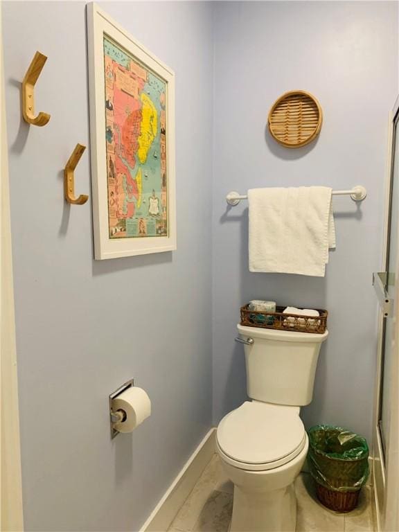 bathroom with tile patterned floors, toilet, and baseboards