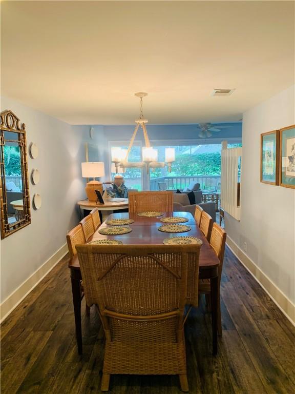 dining space with hardwood / wood-style flooring, visible vents, and baseboards