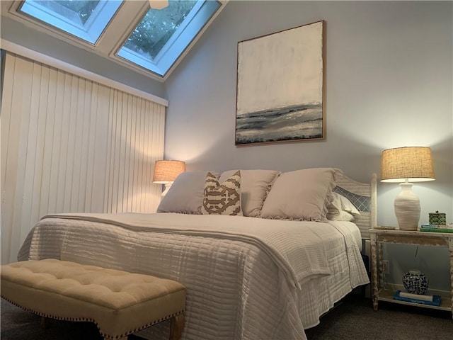 bedroom with lofted ceiling with skylight and carpet floors