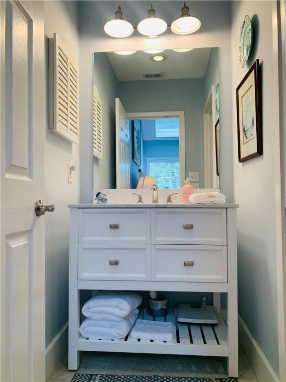 bathroom featuring visible vents, vanity, and baseboards