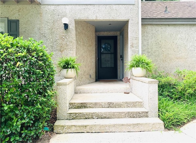 view of exterior entry featuring stucco siding