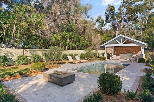 view of swimming pool featuring a fire pit and a patio