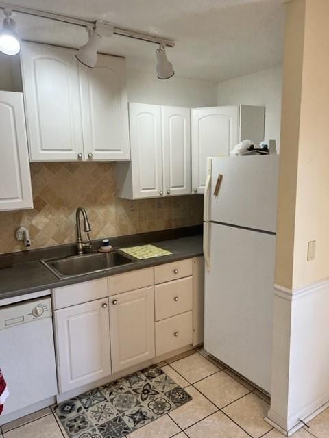 kitchen with white cabinetry, sink, tasteful backsplash, white appliances, and light tile patterned flooring