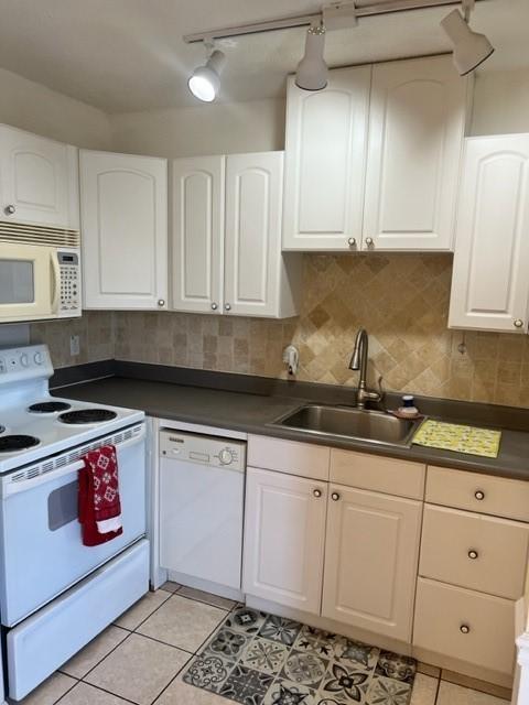 kitchen featuring white cabinetry, sink, light tile patterned floors, and white appliances