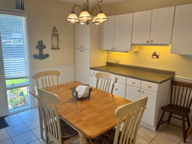 dining space with an inviting chandelier and light tile patterned flooring