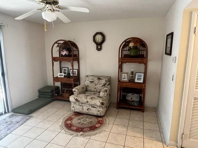 living area with ceiling fan and light tile patterned floors