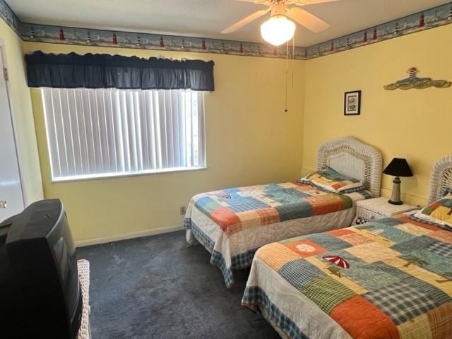 bedroom featuring dark carpet and ceiling fan