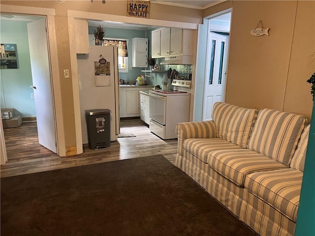 kitchen with hardwood / wood-style flooring, white range with electric cooktop, fridge, and white cabinetry