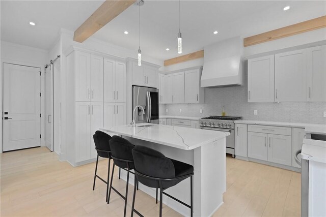 4 Lake View Cottages Ct, Saint Simons Island, GA 31522 - kitchen with appliances with stainless steel finishes, a sink, custom exhaust hood, tasteful backsplash, and light stone counters