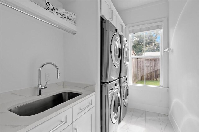 4 Lake View Cottages Ct, Saint Simons Island, GA 31522 - laundry area with stacked washing machine and dryer, light marble finish floors, cabinet space, and baseboards