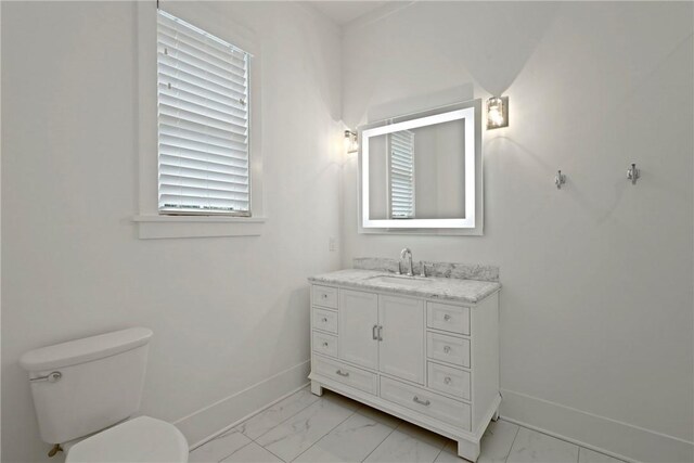 4 Lake View Cottages Ct, Saint Simons Island, GA 31522 - bathroom with marble look tiles, baseboards, vanity, and toilet