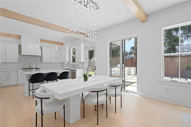 4 Lake View Cottages Ct, Saint Simons Island, GA 31522 - dining space featuring beamed ceiling, plenty of natural light, light wood-style flooring, and baseboards