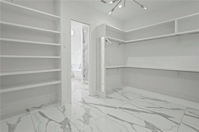 4 Lake View Cottages Ct, Saint Simons Island, GA 31522 - walk in closet featuring marble look tile flooring and a chandelier