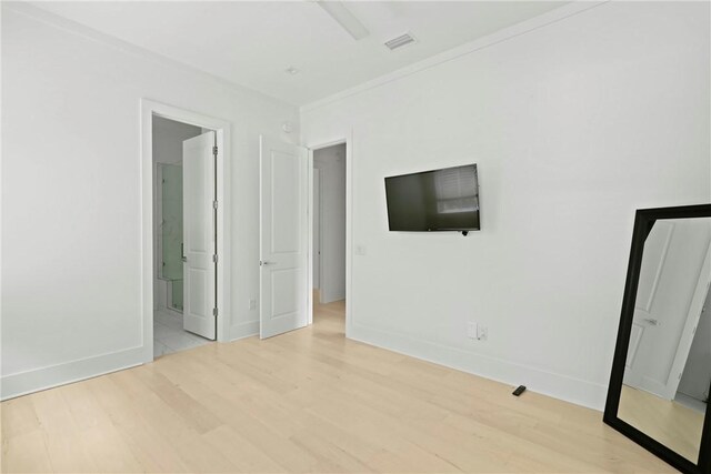 4 Lake View Cottages Ct, Saint Simons Island, GA 31522 - unfurnished bedroom featuring light wood-style floors, baseboards, and connected bathroom