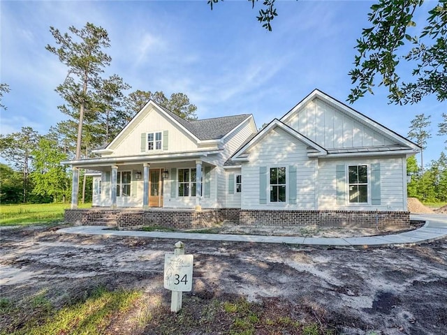 1047 Tranquility Pl NE, Townsend, GA 31331 - view of front of home with covered porch, board and batten siding, and brick siding