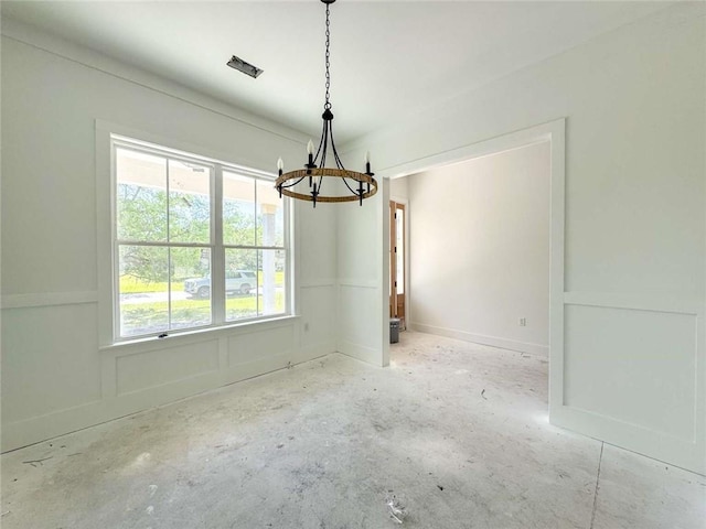 unfurnished dining area featuring a chandelier