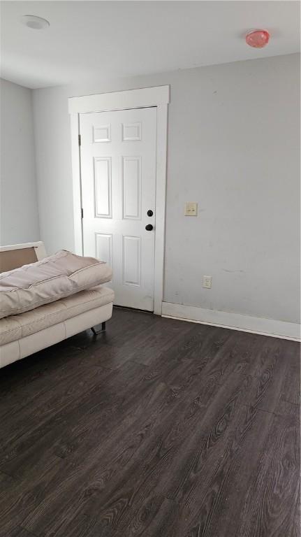 unfurnished bedroom with dark hardwood / wood-style flooring